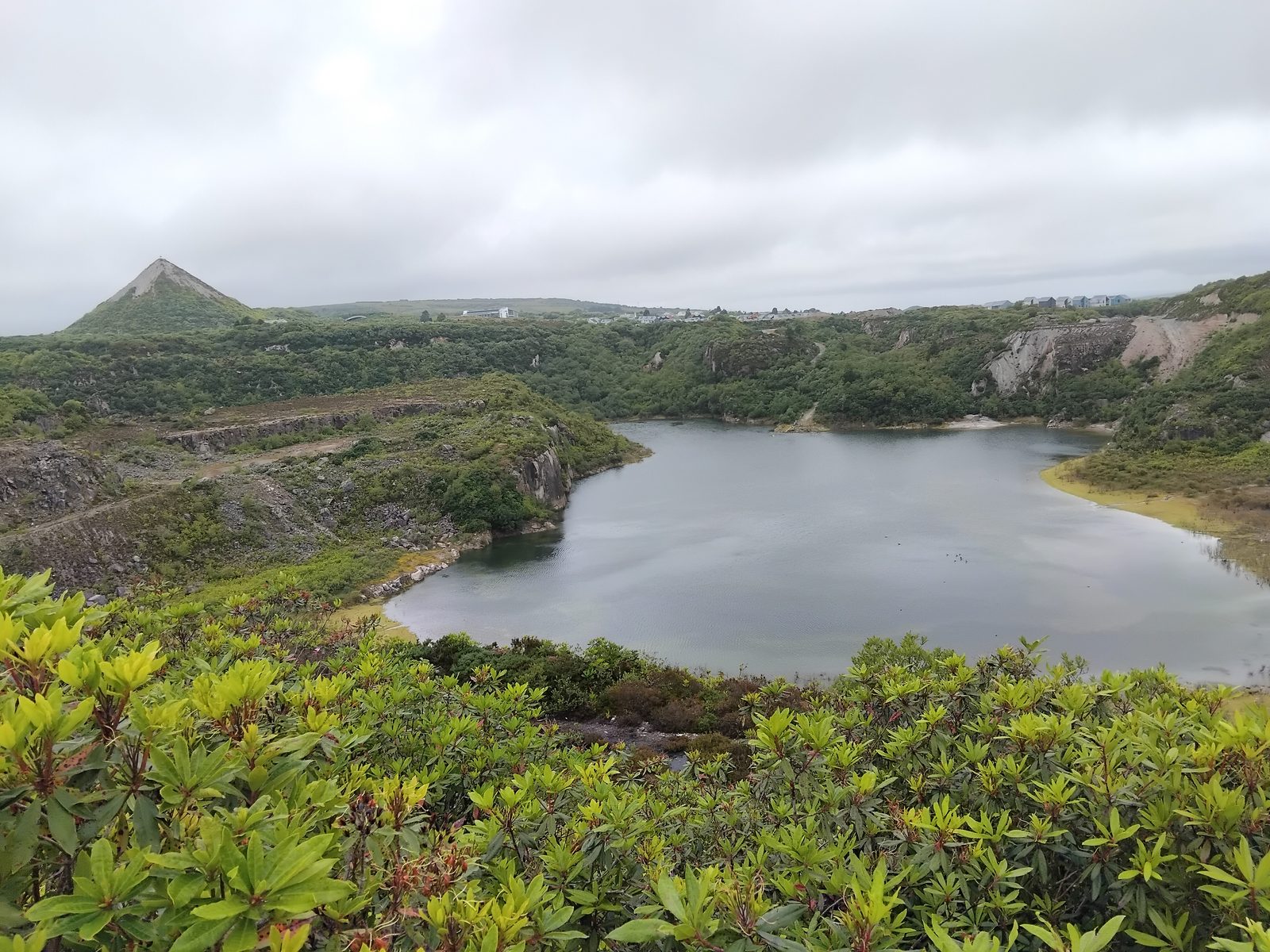The turquoise pit lake and white sky tip of the Great Carclase china-clay works near Bugle